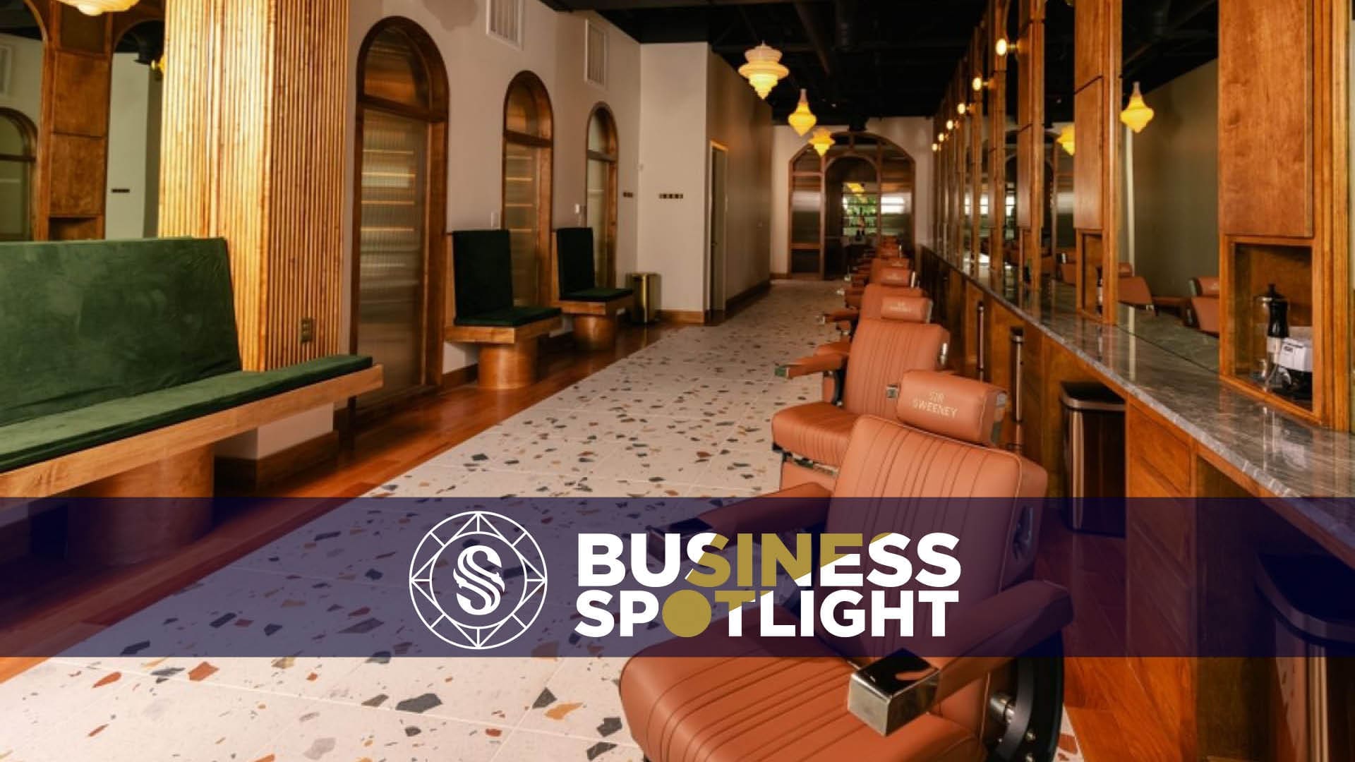 A stylish salon with leather chairs, wooden decor, large mirrors, and modern lighting. A “Business Spotlight” banner overlays the image near the bottom.